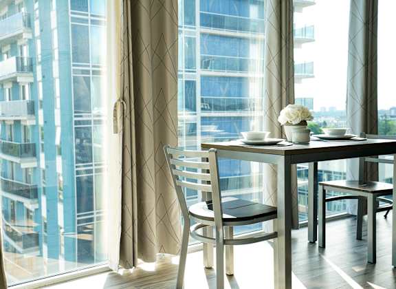 a room with a table and chairs in front of a window
