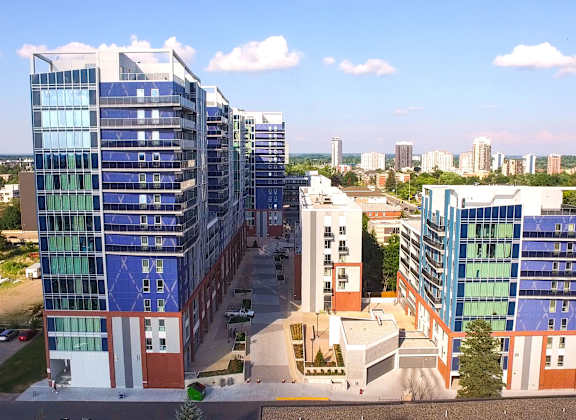 an aerial view of a cluster of buildings with a city in the background