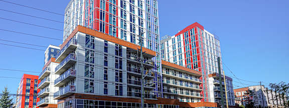 a group of tall buildings with orange balconies on a city street