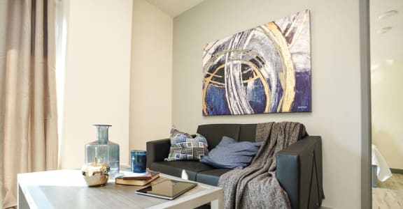 a living room with a couch and a table and a painting on the wall