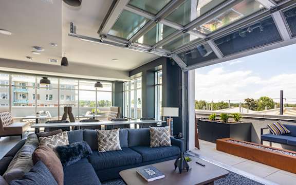 A modern living room with a dark blue couch and a glass ceiling. at Railside at Wadsworth Station, Lakewood, CO