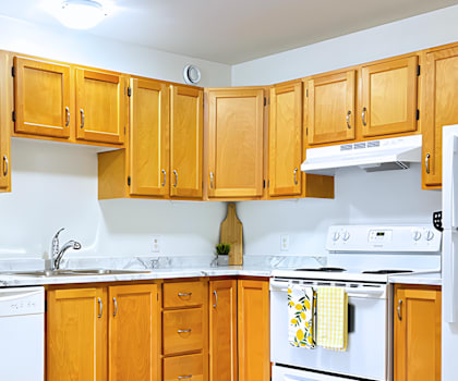 A kitchen with wooden cabinets and white appliances.