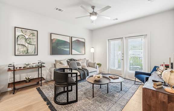 A living room with a black chair, a coffee table, and a painting on the wall.