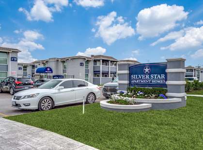a car parked in front of a building with a sign for silver star apartments