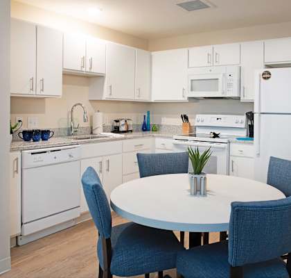 a kitchen with white appliances and a white table and chairs at Parks Residential - Richardson, Richardson, 75082