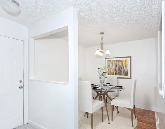a bedroom with white walls and wood flooring and a closet