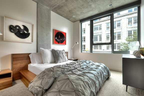 a bedroom with a bed and a large window