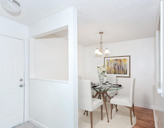 a dining room with a glass table and white chairs