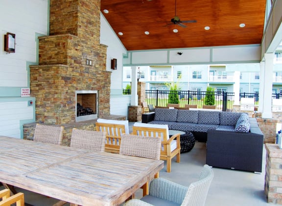 a patio with a table and chairs and a fireplace