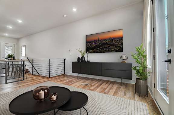 an open living room with a tv on the wall and a table and chairs