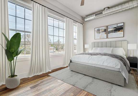 a bedroom with a bed and windows with white curtains