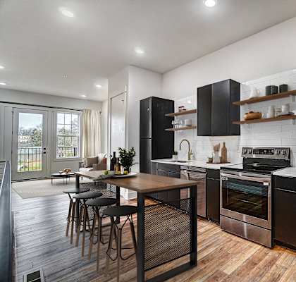 a kitchen with stainless steel appliances and a wooden table