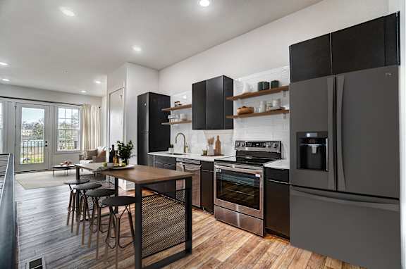 a kitchen with stainless steel appliances and a wooden table