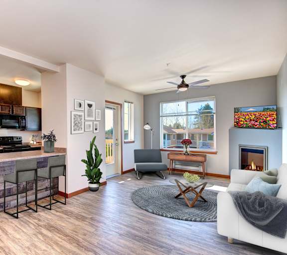 A modern kitchen with a bar and a living room with a fireplace.