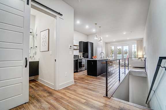 an open kitchen and living room with a staircase leading to a balcony