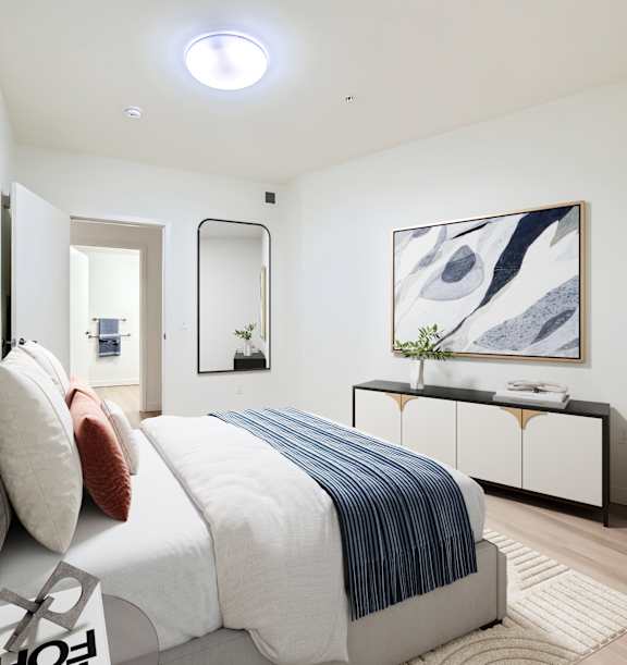 A bedroom with a bed, nightstand, and lamp.