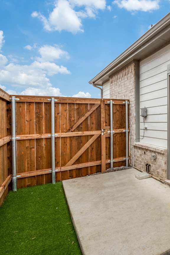 A house with a grey door and a brown fence.