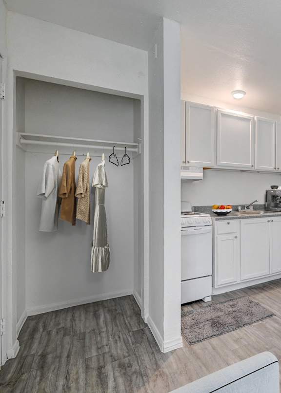 A white kitchen with a washing machine in the corner.