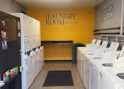 Thumbnail 7 of 14 - a laundry room with rows of washes and dryers