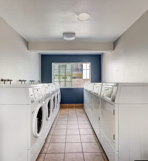 a laundry room with white washers and dryers