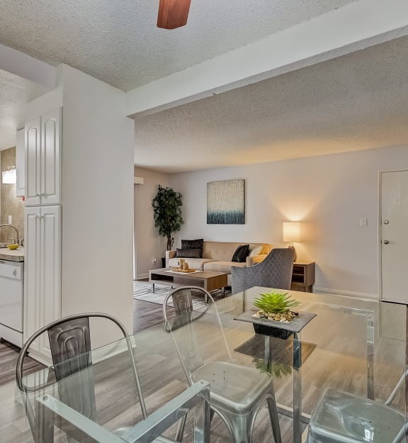 a living room and dining room with a glass table and chairs