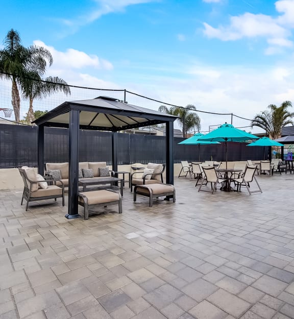 a patio with tables and chairs and umbrellas