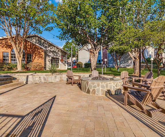 A patio with chairs and a fire pit.