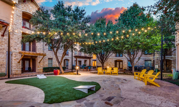 the courtyard at our apartments is decorated with lights and grass