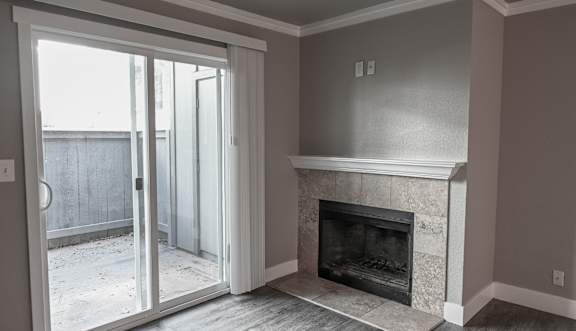 an empty living room with a ceiling fan