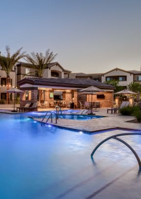 a swimming pool with chaise lounge chairs and umbrellas in front of a hotel