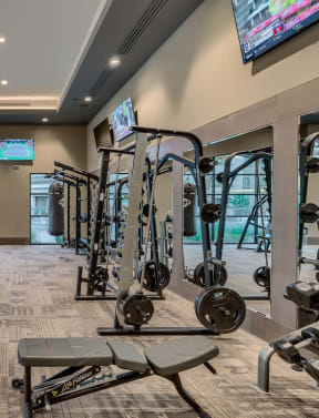 a spacious fitness room with cardio equipment and weights