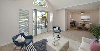 a living room with blue chairs and a white coffee table and a sliding glass door