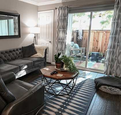 a living room with a couch and chair in front of a sliding glass door