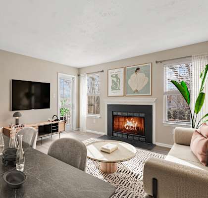 a living room with a fireplace and a table and chairs at Madison at Eden Brook, Columbia