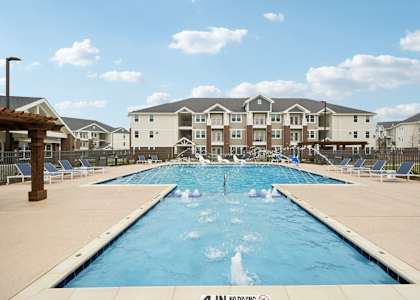 A large swimming pool in front of apartment buildings.
