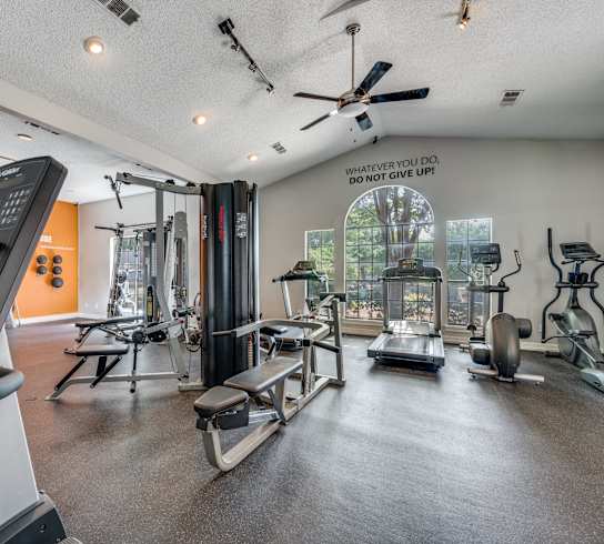 spacious gym with cardio machines and weights at the everyday gardener apartments at Foxborough Apartments, Irving, TX