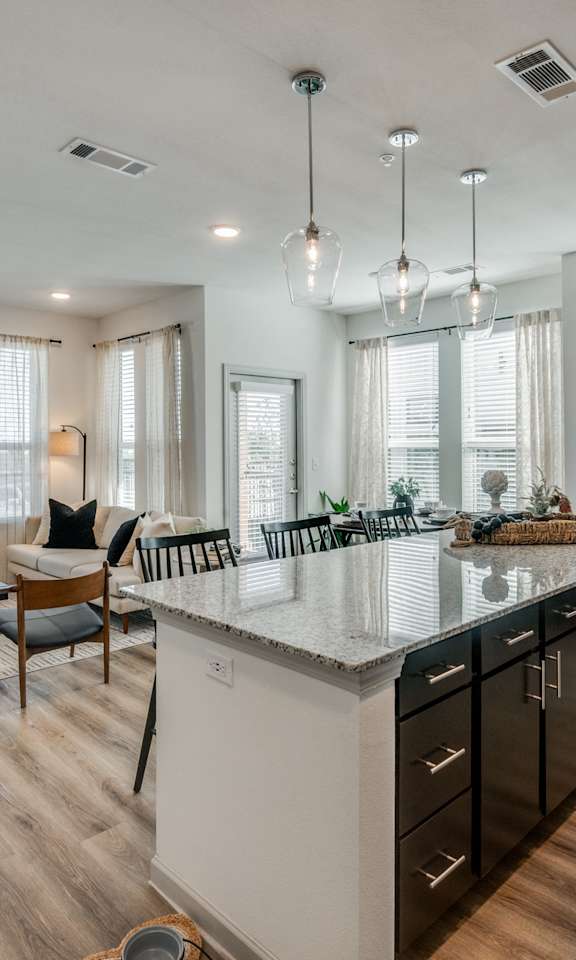 A modern kitchen with a large island and wooden floors.
