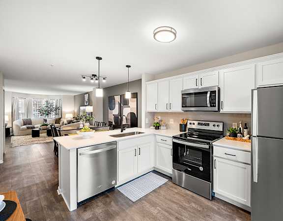 A modern kitchen with stainless steel appliances and white cabinets.