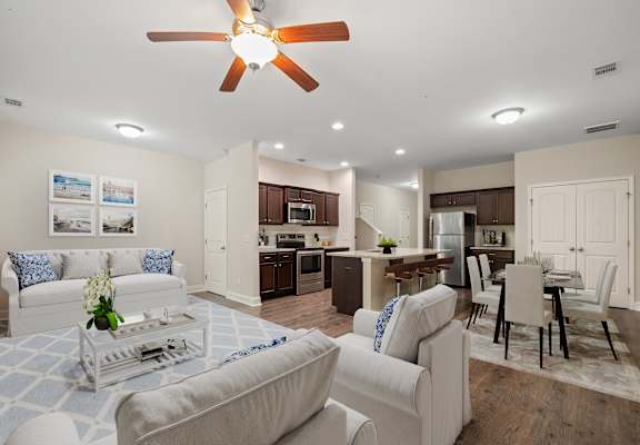 a living room and kitchen with couches and a table