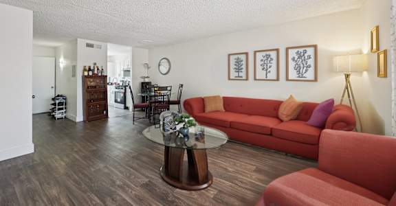 A living room with a red couch and a coffee table.