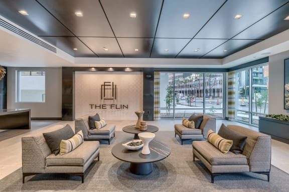 a lobby with couches and chairs in front of a large window