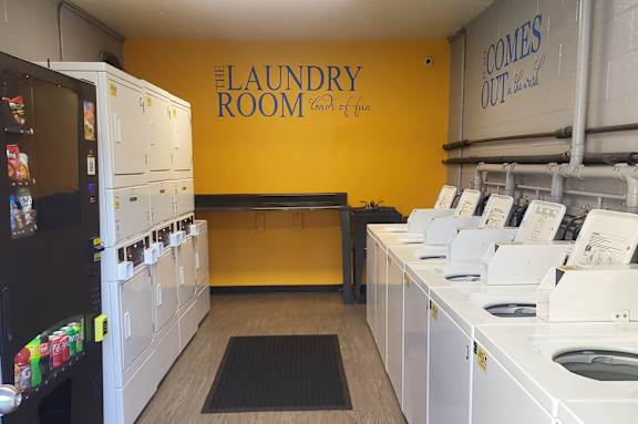 a laundry room with rows of washes and dryers