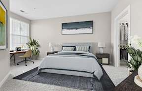 A bedroom with a large bed and a painting on the wall.