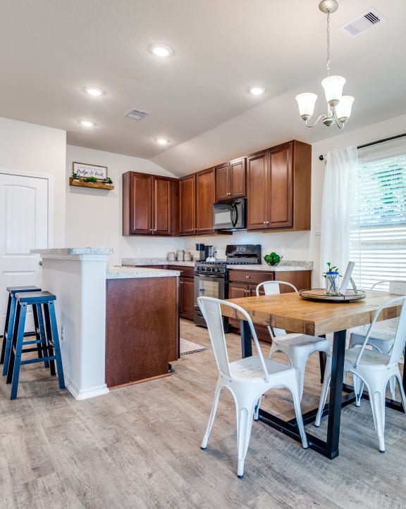 a kitchen and dining area with a wooden table and chairs