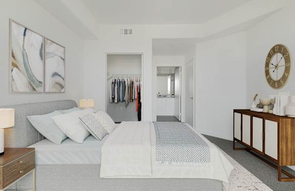 A bedroom with a large bed and a painting on the wall.