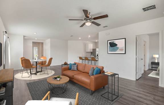 A living room with a brown couch and a ceiling fan.