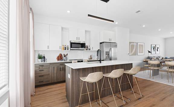 A modern kitchen with a bar stool in front of it.