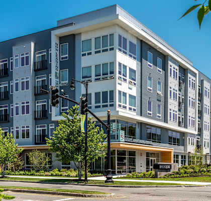 A modern multi-story building with a mix of grey and white exterior.