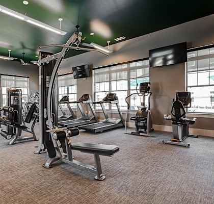 a large fitness room with treadmills and other exercise equipment