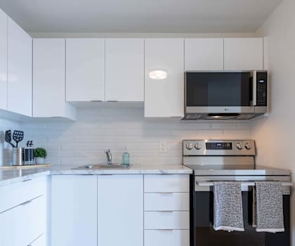A modern kitchen with white cabinets and appliances.
